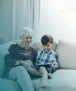 Shot of a little boy using a digital tablet while spending some time with his grandmother